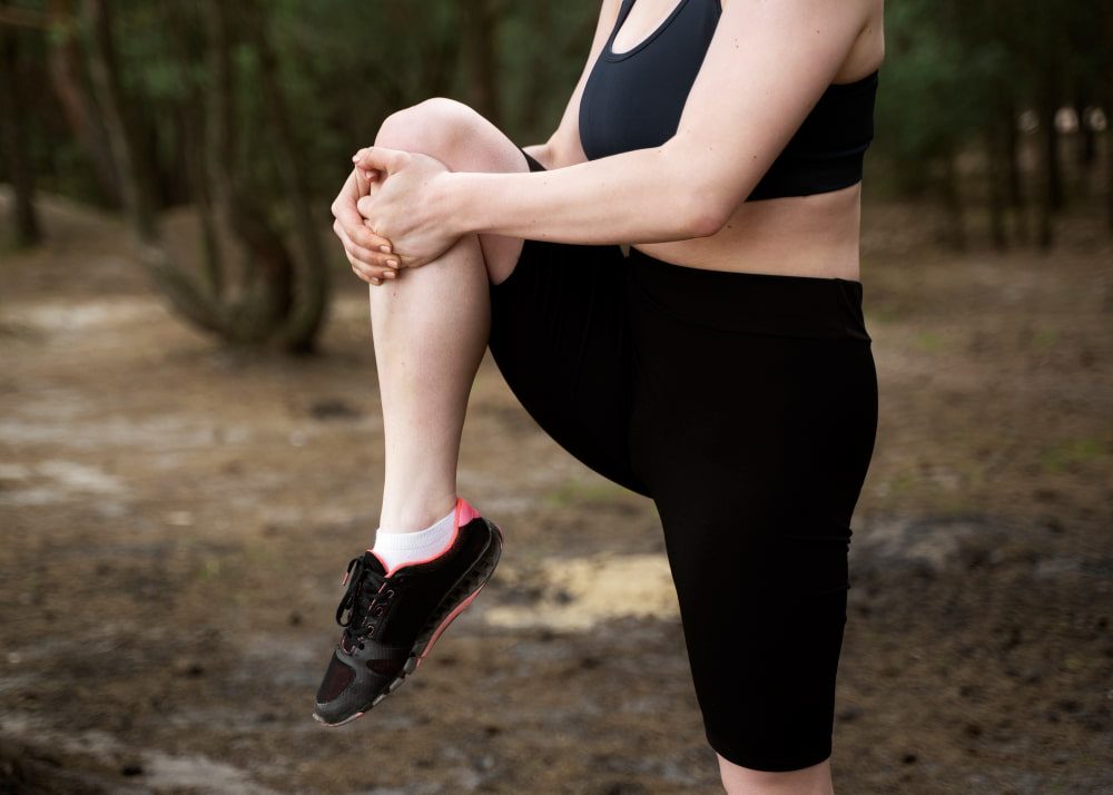 Comment éviter les courbatures : une femme s'étire la jambe